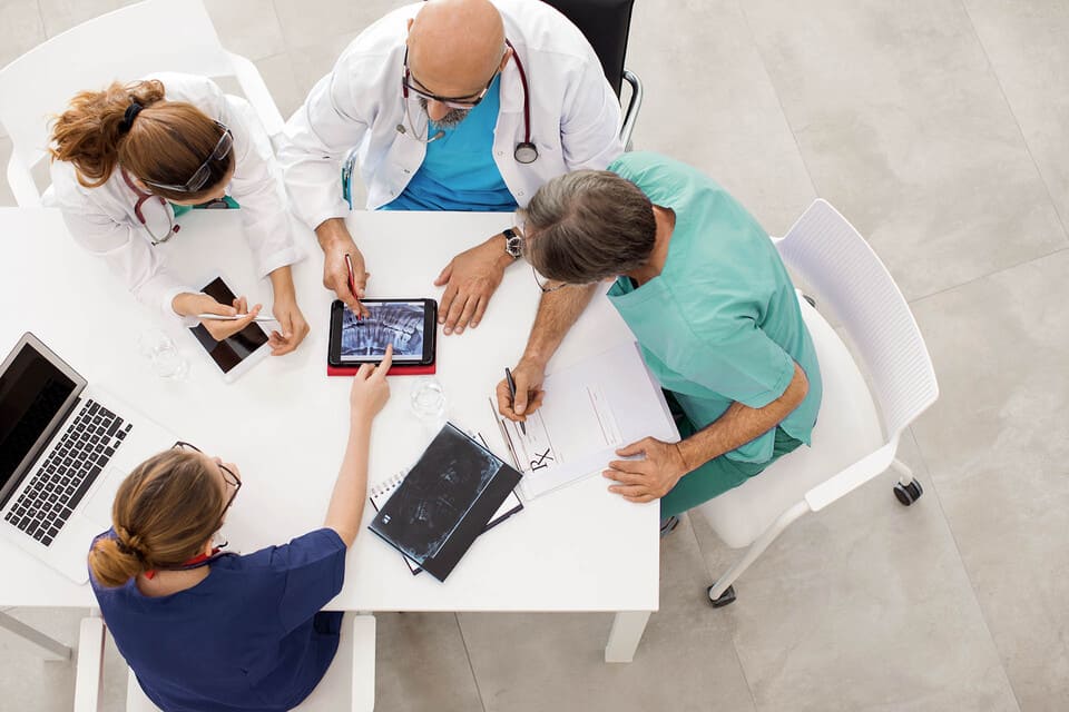 immagine di un gruppo di medici e infermieri che siedono ad un tavolo